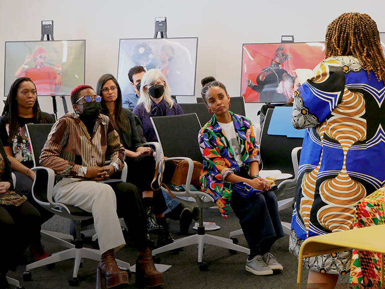 A group of people in an audience listening to someone speak